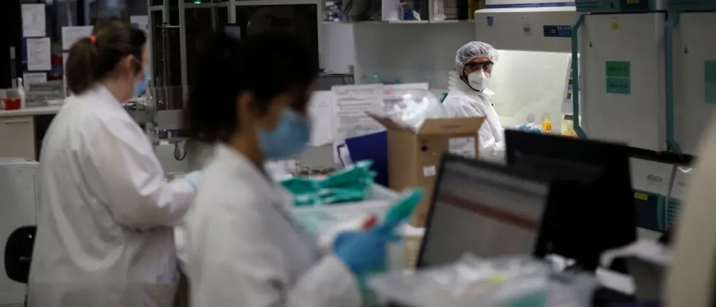 Scientists in protective gear work in a laboratory setting, emphasizing the importance of safety and hygiene in research environments.