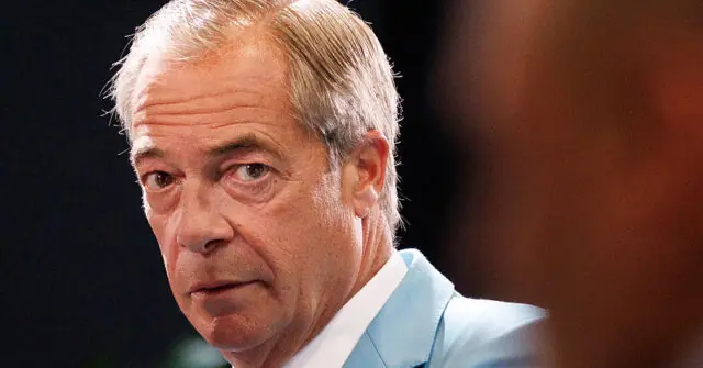 The image shows a man in a light blue shirt, appearing to be in a formal or professional setting.