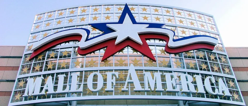 The image shows the iconic sign of the Mall of America, featuring a large star and the text "MALL OF AMERICA" surrounded by stars.