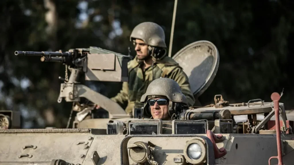 The image shows two soldiers in military attire operating a tank, with one of them wearing sunglasses and the other aiming a mounted machine gun.
