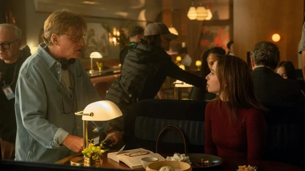 A man and a woman are engaged in conversation at a restaurant, with the man leaning in towards the woman.