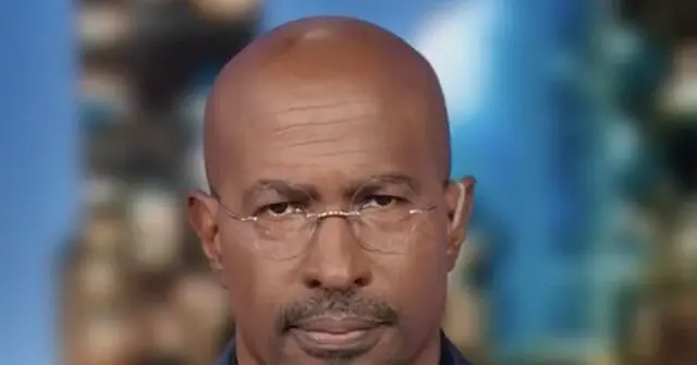The image shows a close-up of a man wearing glasses, with a blurred background that appears to be an outdoor setting.