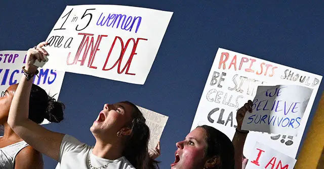 The photo captures a group of protesters holding signs advocating for women's rights and calling for justice against sexual violence.