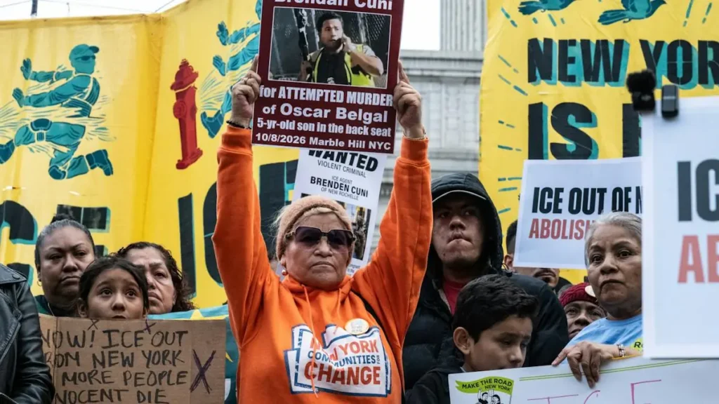 A protestor holds up a sign calling for the release of Oscar Belgal, while others hold signs advocating for the abolition of ICE and community change.